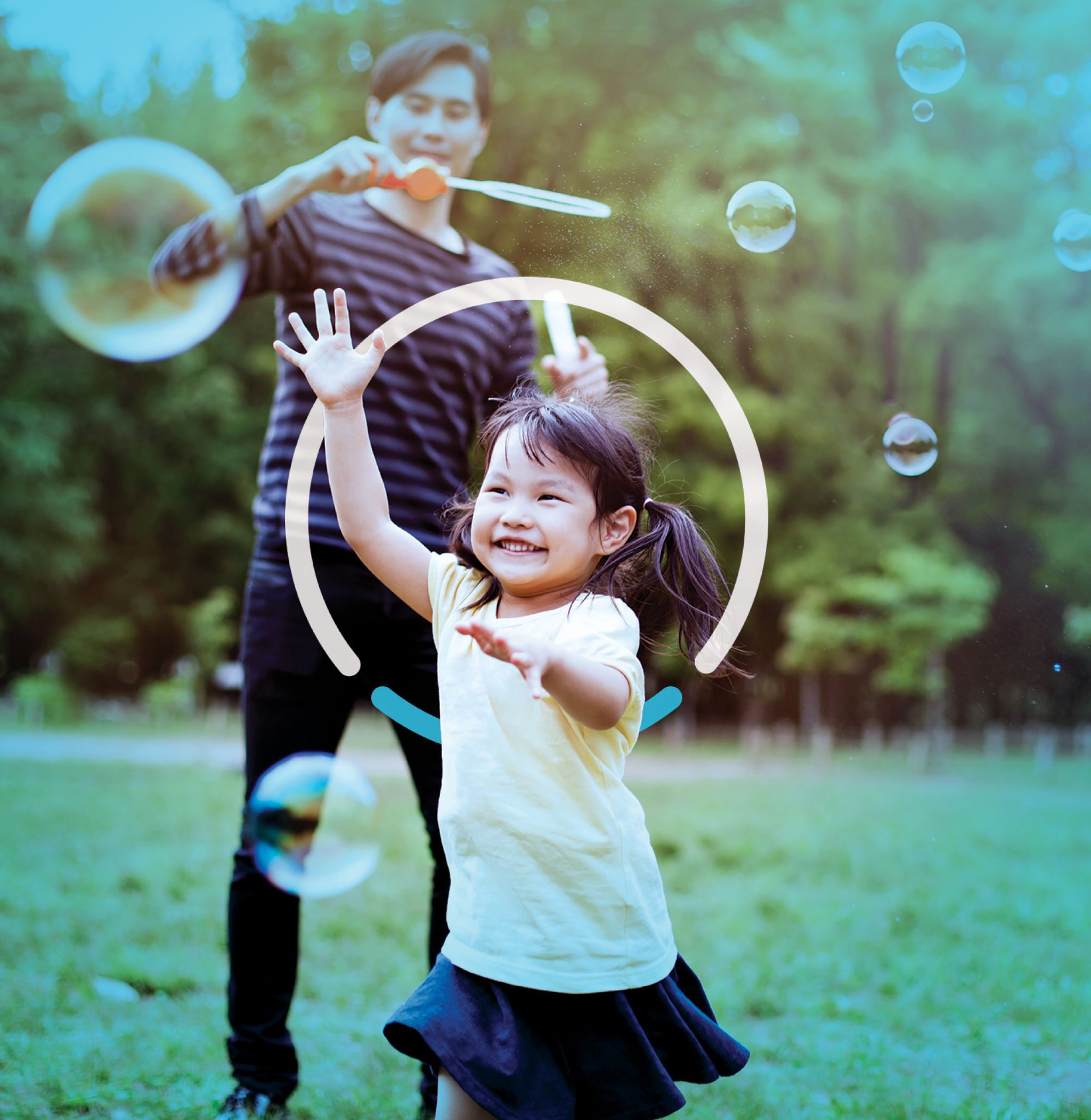 An adult and child play with bubbles outside