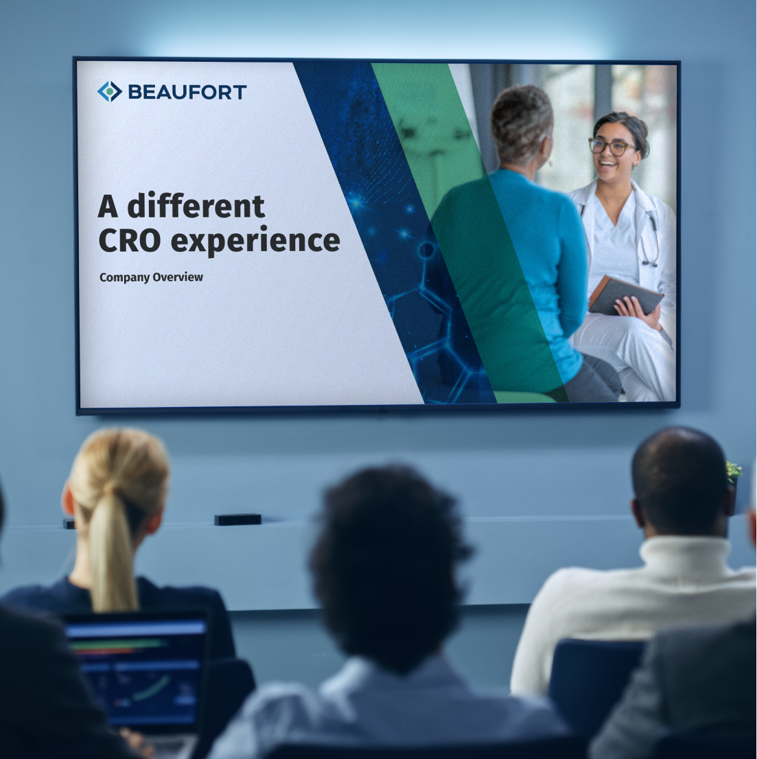Three professionals watch a presentation screen, featuring a Beaufort-branded slide that reads "A different CRO experience." 