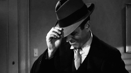 A GIF of actor Humphrey Bogart pulling his fedora over his eyes.