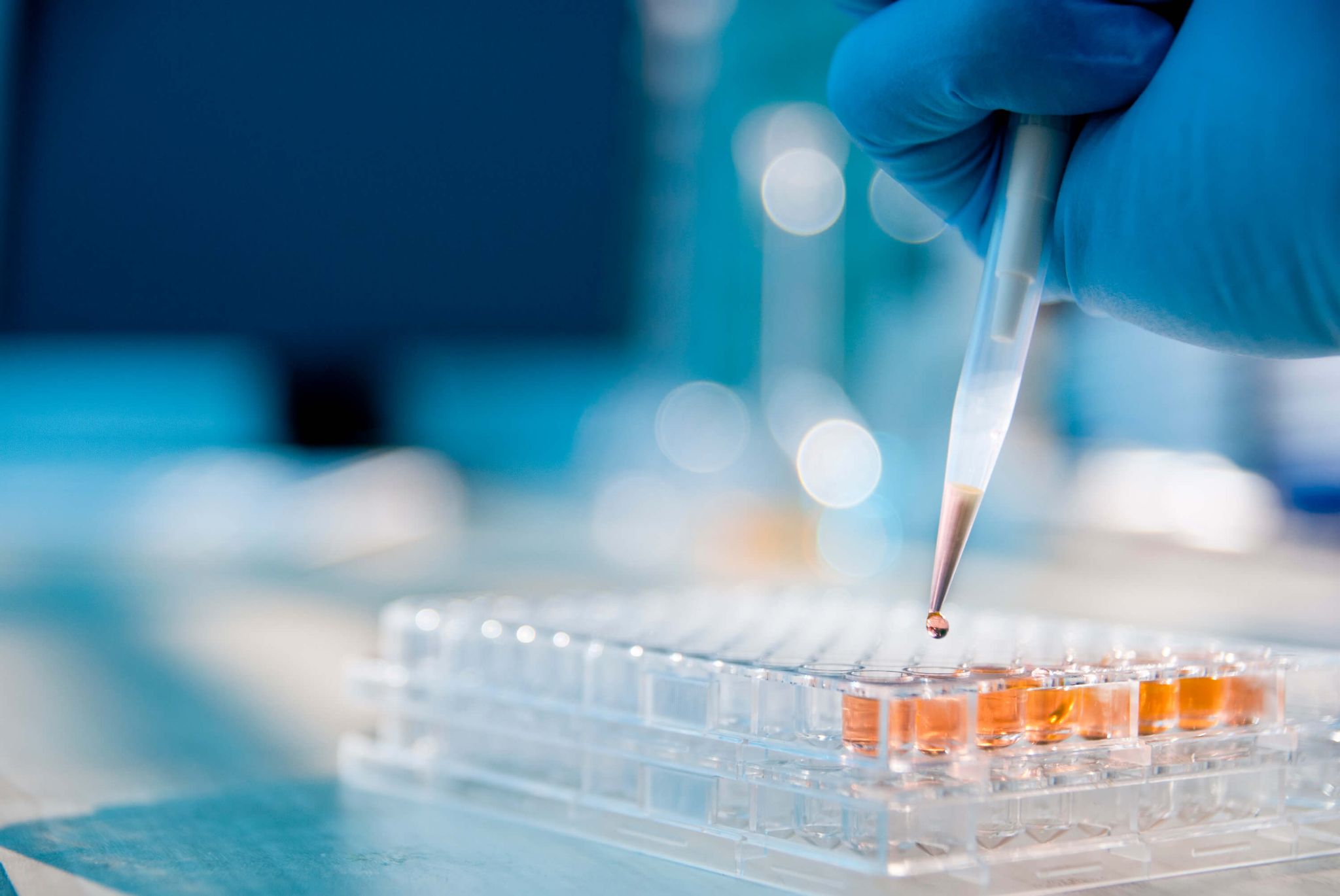 A closeup photo of a scientist using a pipette.