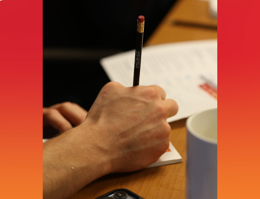 A closeup photo of a hand writing on a notepad
