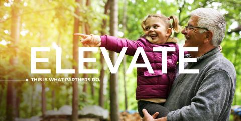 An elderly person carries a child whom is pointing into the distance. Header text: Elevate, this is what partners do