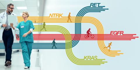 Two medical professionals talk in a hallway filled with stylized arrows in the Thermo Fisher Scientific Oncomine colors